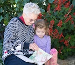 Wesley Mission Brisbane aged care resident, Joan, and Lily, from the Wheller Gardens on-site Little Marchants Child Care Centre, enjoy reading together.