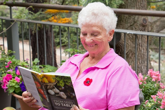 <p>Noble Park resident and contributor Margaret Nicholson with the cookbook.</p>
