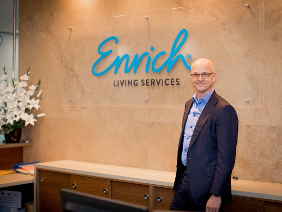 <p>Enrich CEO Norbert Walther with the new name logo (Source: Enrich)</p>
