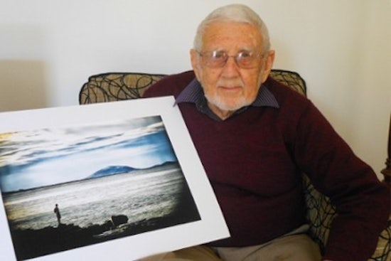 <p>Resident John Speers sits with his painting</p>
