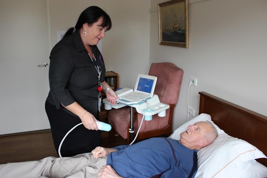 <p>Karin Woods, Villa Maria Wantirna care manager, using the new machine on resident Bill Davis.</p>
