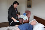 Karin Woods, Villa Maria Wantirna care manager, using the new machine on resident Bill Davis.