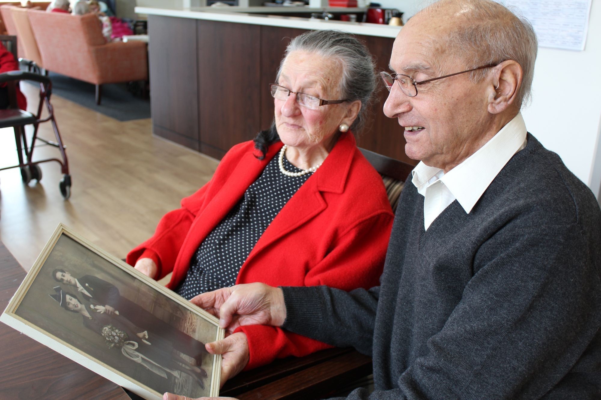 <p>Frank and Jane Gauci looking at their wedding photo taken 70 years ago.</p>
