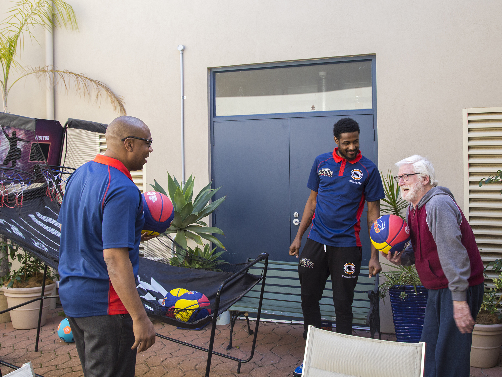 <p>Adelaide 36ers coach Joey Wright, player Ramone Moore, and Ananda Aged Care resident Gerry, 69-years-old (Source: Ananda)</p>
