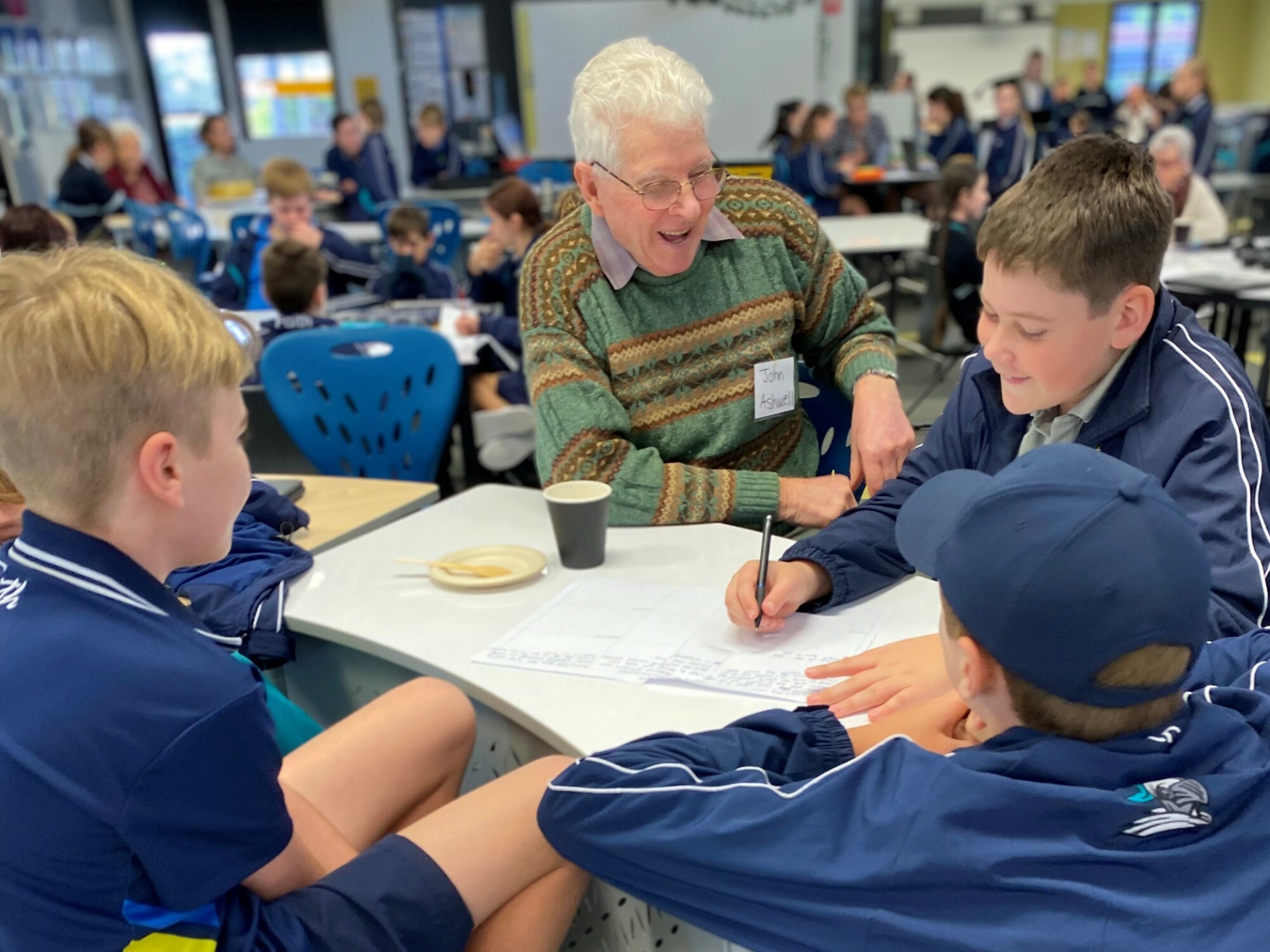<p>John, a resident of Bolton Clarke’s Westhaven Retirement Village, with students from Faith Lutheran College in Queensland. [Source: iStock]</p>
