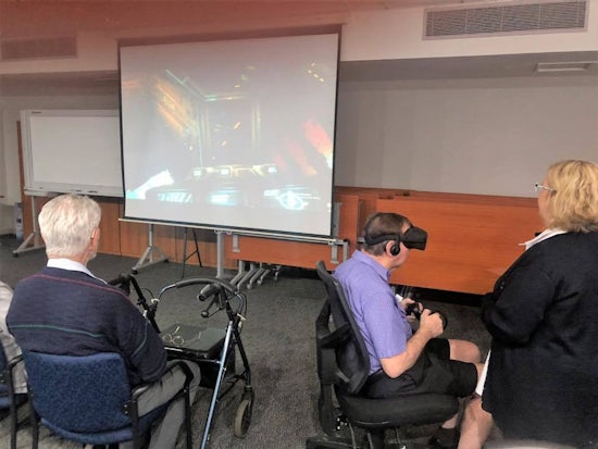 <p>Anglican Care Booragul resident, Bruce Wilson, trying out the new VR technology, watched by fellow resident, Bruce Dunne and staff member, Donna Thomas. [Source: Anglican Care] </p>
