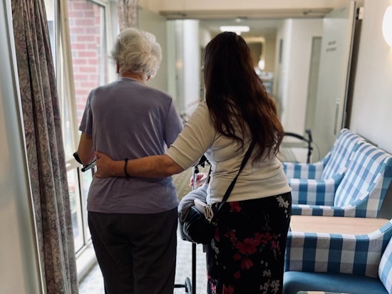 <p>Della dale Aged Care resident, Elizabeth, walking with her daughter, Cathie. Her family have been volunteering at the home to keep up some of their carer duties for Elizabeth. [Source: Supplied]</p>
