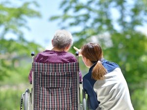 Older woman taking a turn around the garden with her daughter
