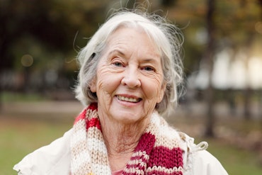 An old woman smiles at the camera.