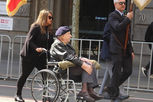 Sydney, NSW Australia - April 25 2021: Anzac Day March. Elderly veteran being pushed by a woman in the march