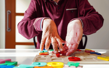 A person pushing an alphabet puzzle around