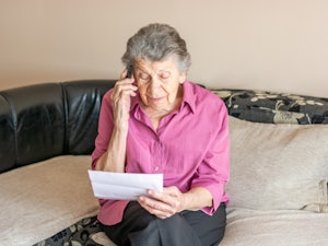 Older woman waiting on the phone.