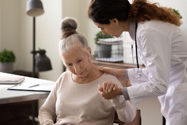 A confused woman is comforted by a doctor