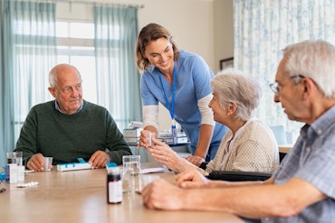 A nurse gives older adults medications