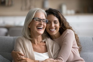 A younger woman hugs an older one