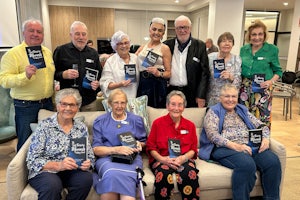 People sit on a couch holding the same book