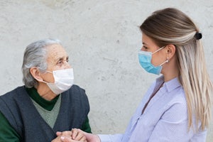 An older woman and younger woman wear masks