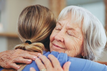 An older woman hugs a younger one