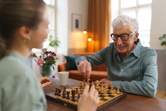 <p>Senior man playing chess with his caregiver.</p>