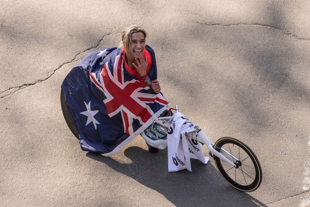 A woman uses a wheelchair for racing and has an Australian flag