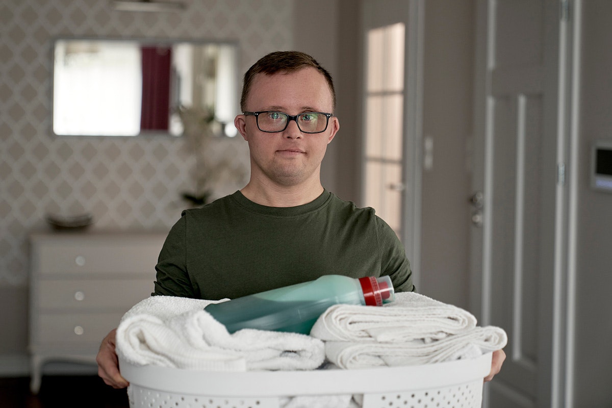 Man carrying laundry basket [Source: Shutterstock]