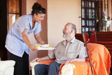 Aged care worker tending to older man