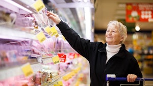 Older woman deciding on food in a supermarket