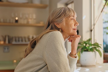 A woman looks out the window while thinking