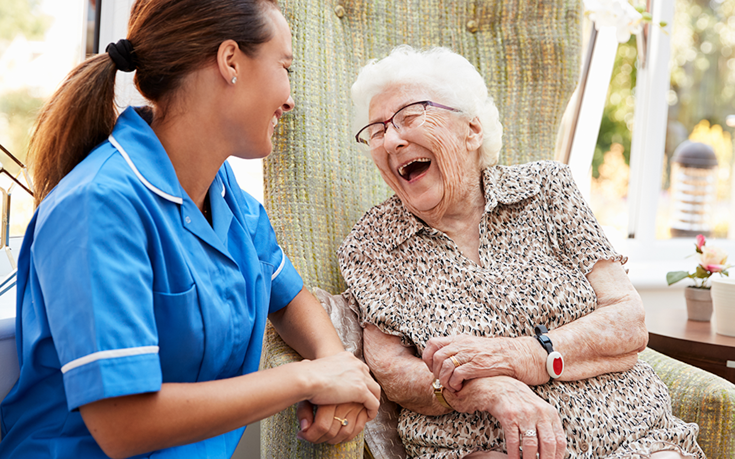 Elderly female laughing with a carer