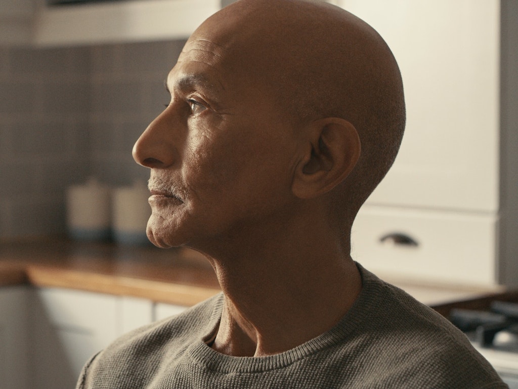Close up of an older man's face from the side, he is looking to the left of the camera.