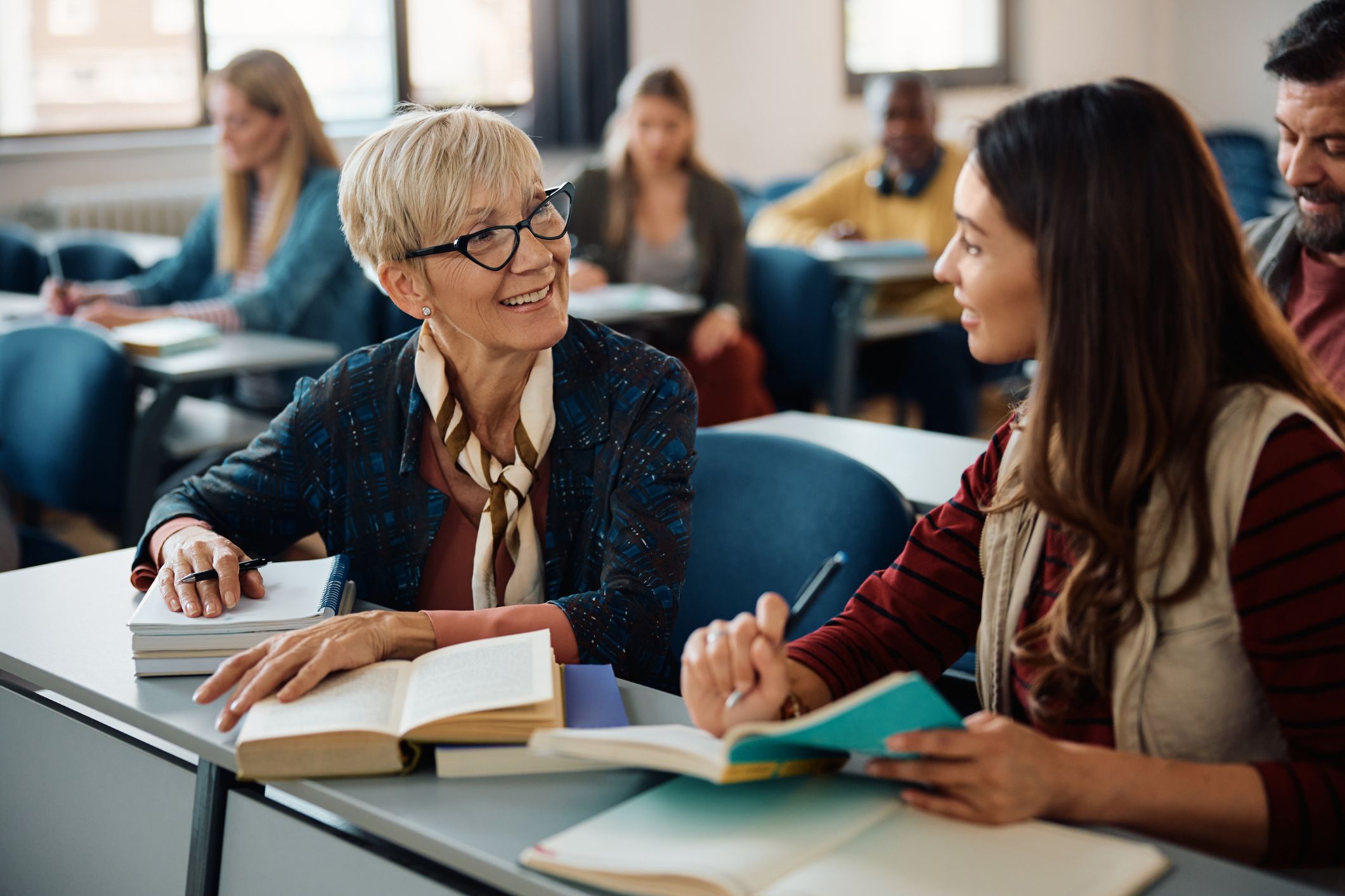 An older woman looks at a younger lady while studying.