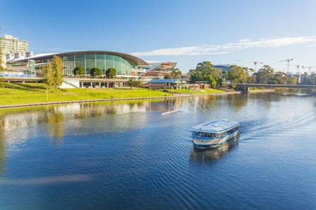 A boat runs on the river in Adelaide City