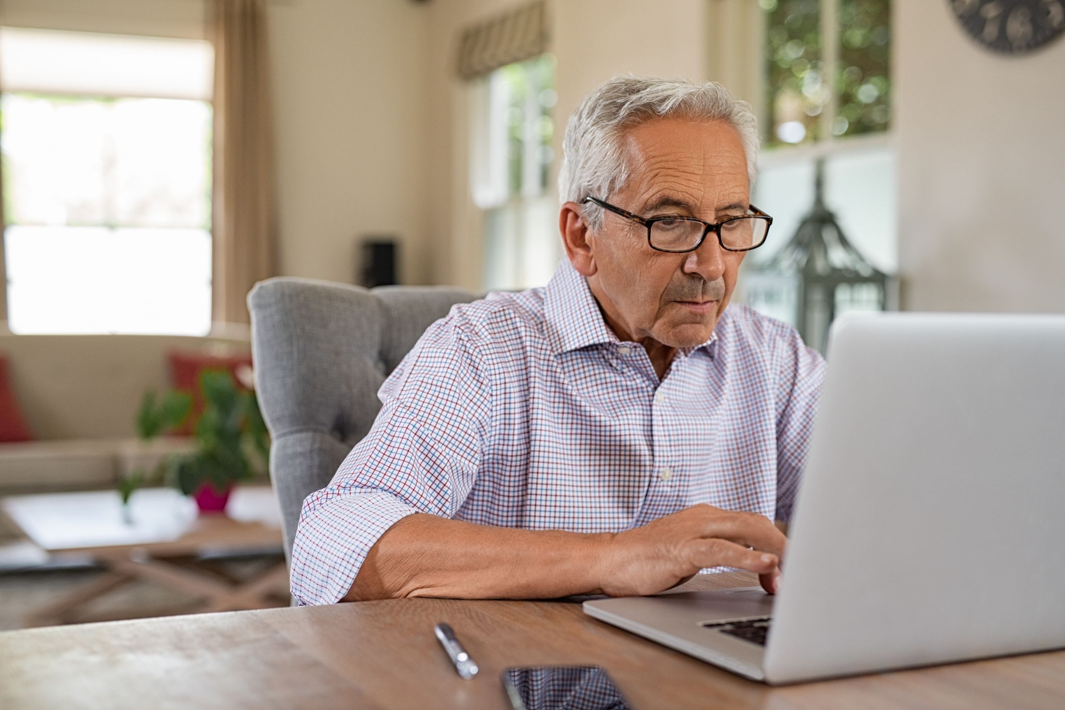 An older man works on a laptop